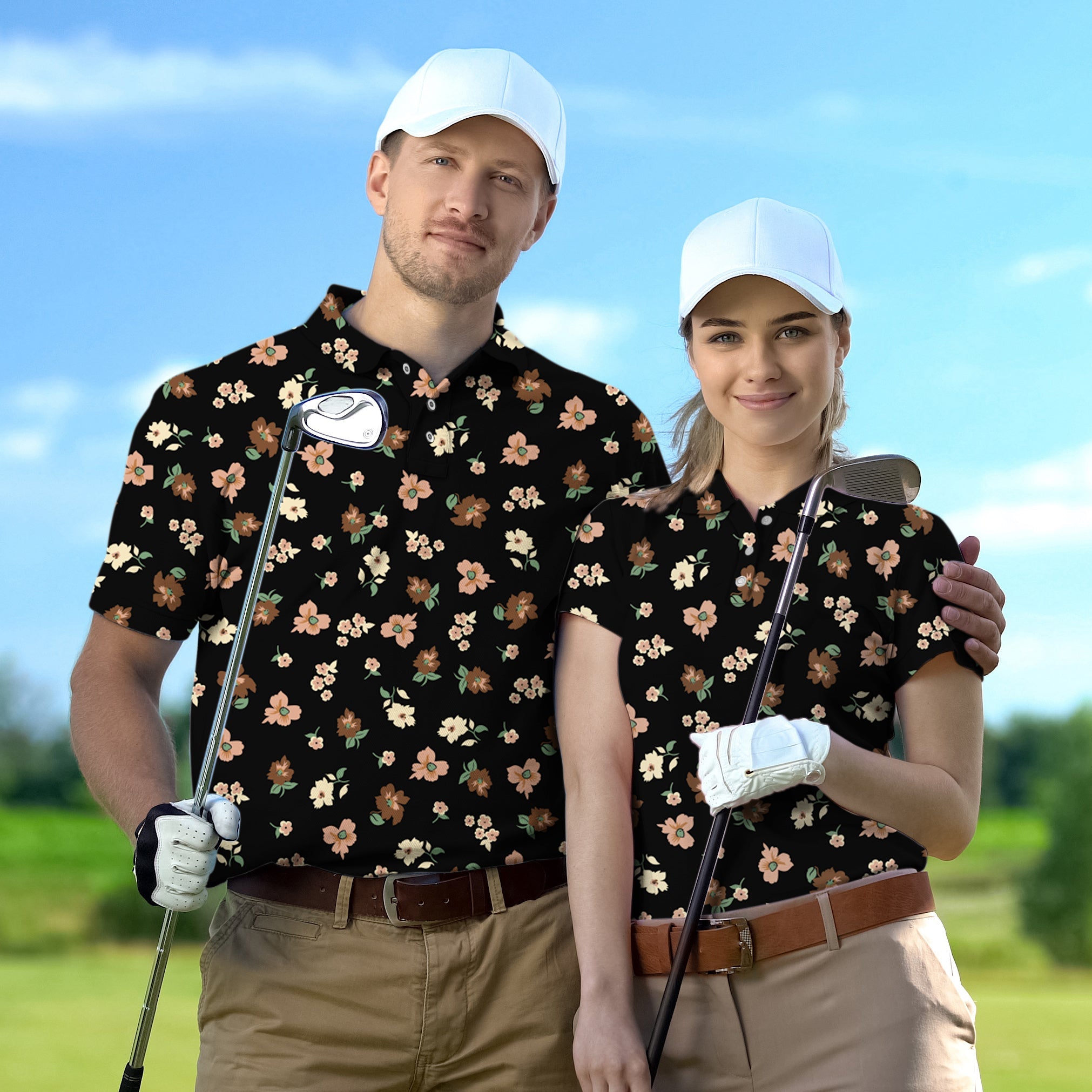Couple wearing black floral golf polos with white caps holding golf clubs on golf course