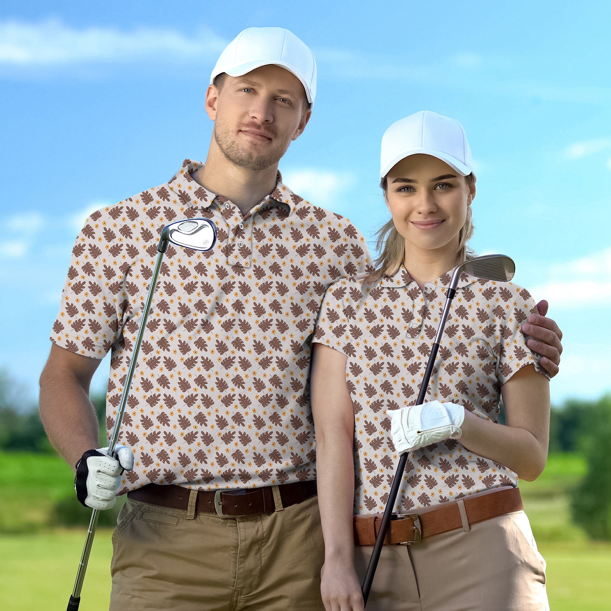 Couple wearing brown palm leaf golf polo shirts holding golf clubs on a sunny golf course