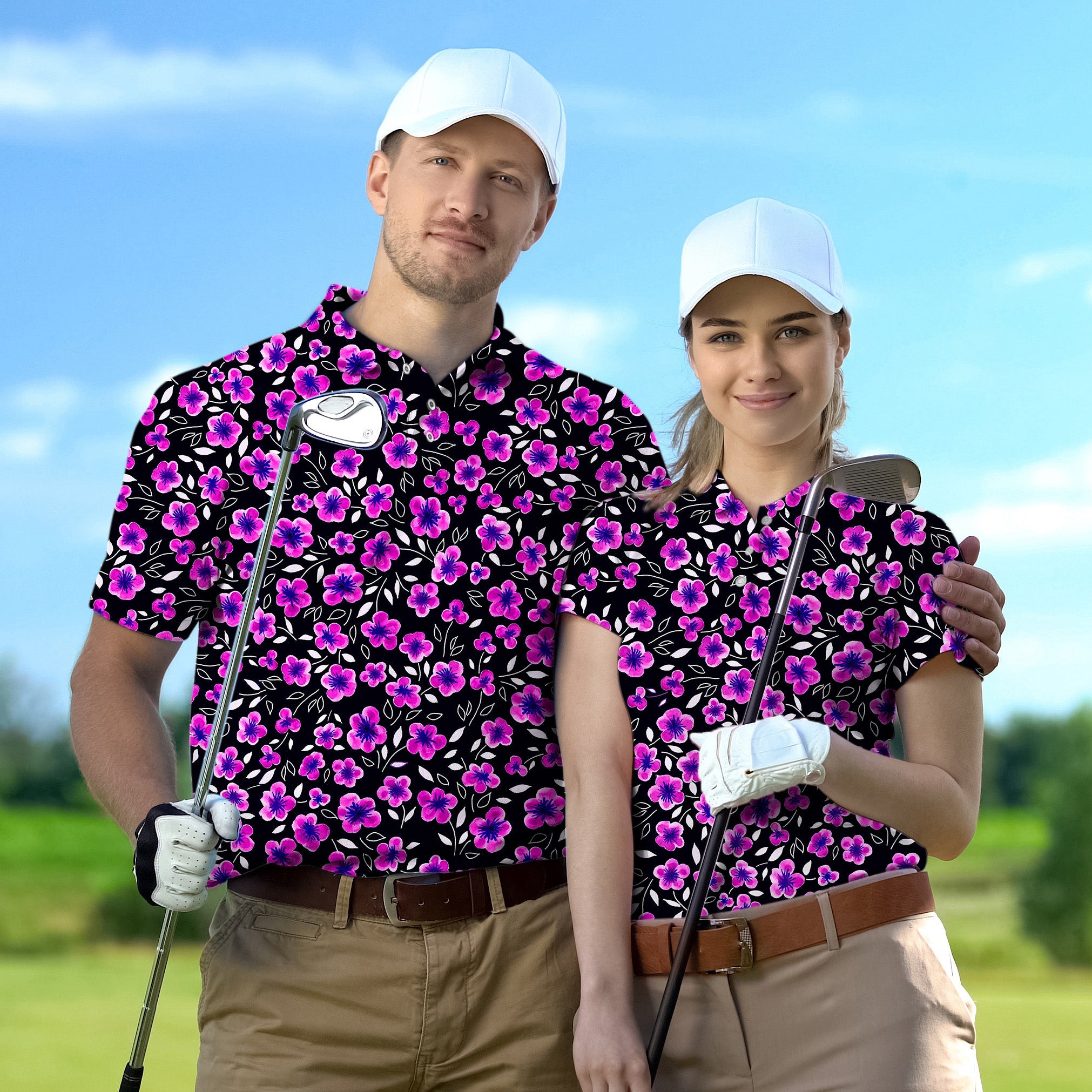 Couple wearing Floral Out set golf shirts with purple flowers and white caps holding golf clubs on a golf course