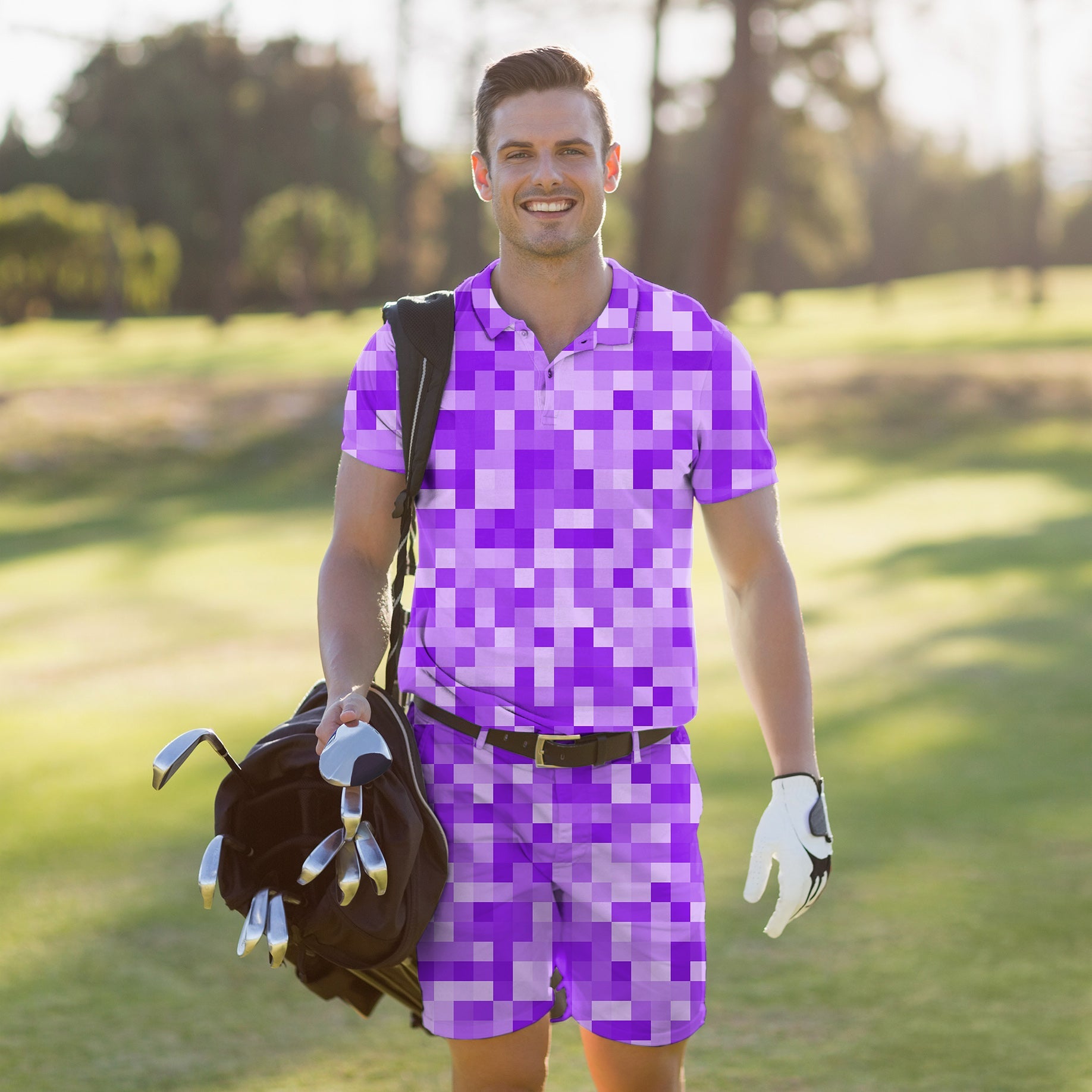 Man wearing purple pixel patterned men's golf set polo and shorts carrying golf clubs on course