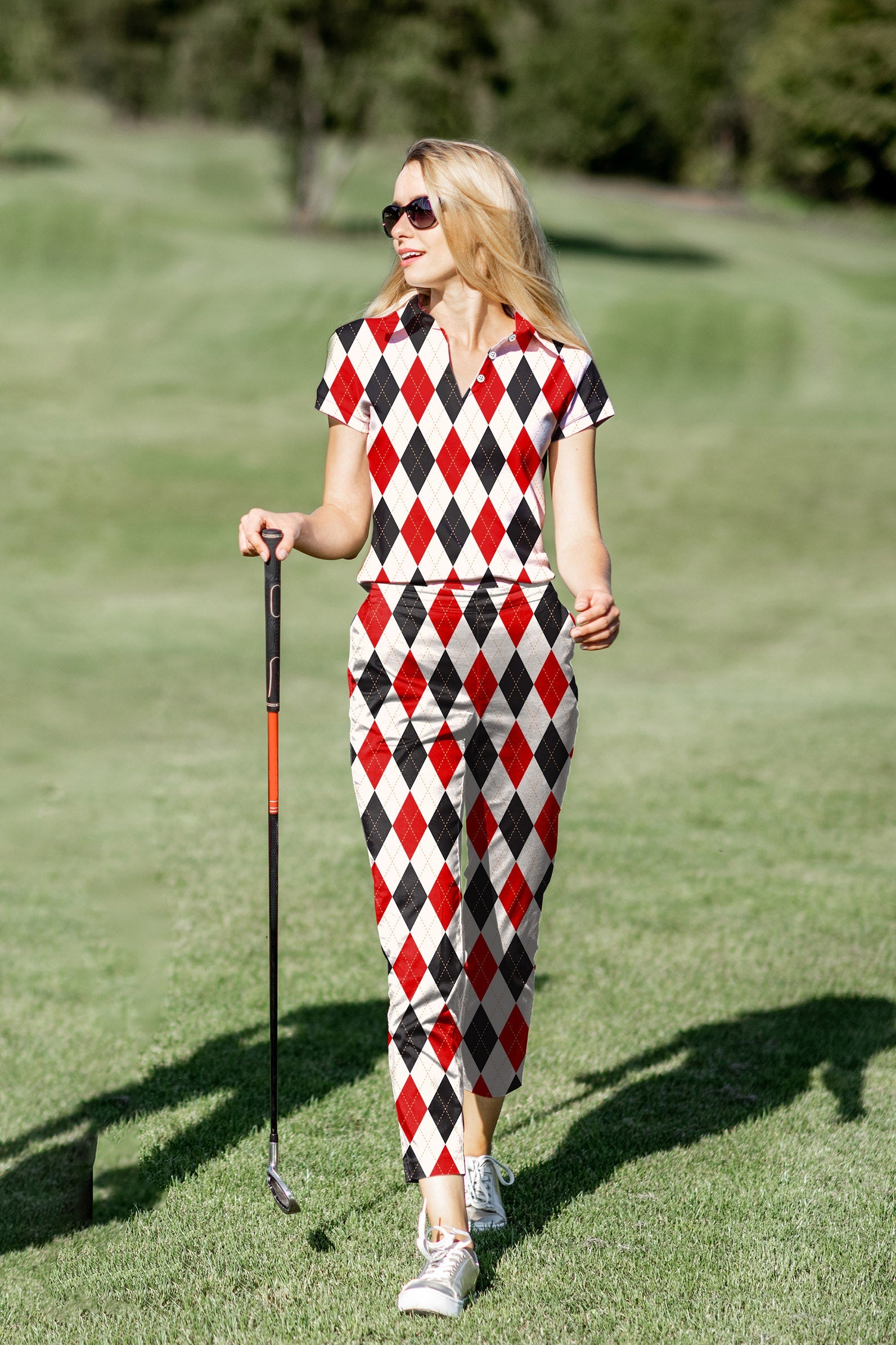 Women's golf polo and pants set in red and black argyle pattern designed for comfort and style on the green