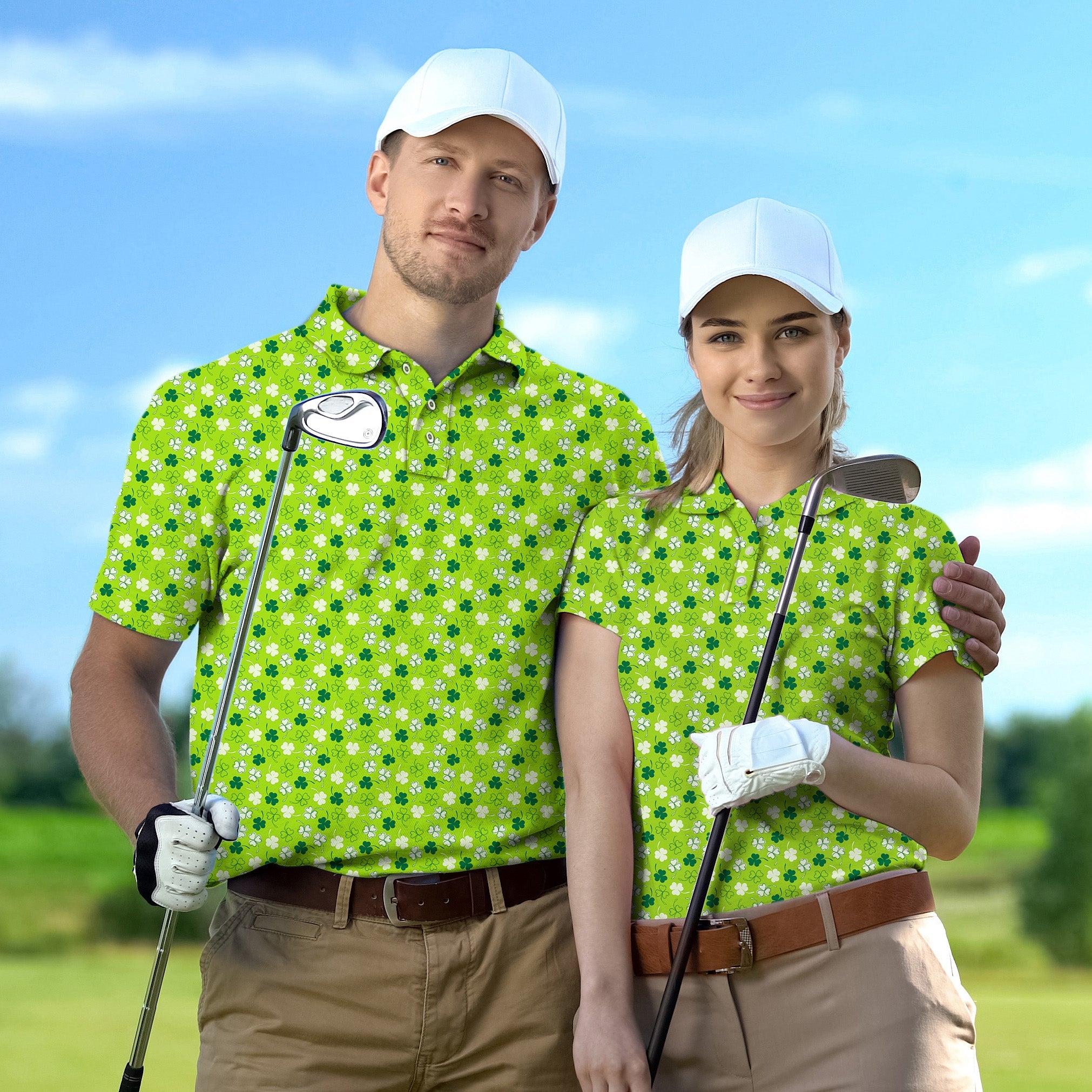 Couple wearing green leaf clover golf polo shirts with white caps holding golf clubs on a golf course