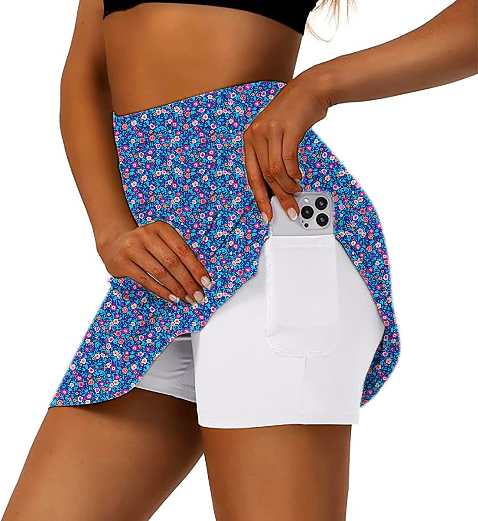 Women's blue floral golf skirt with inner shorts and pocket holding smartphone