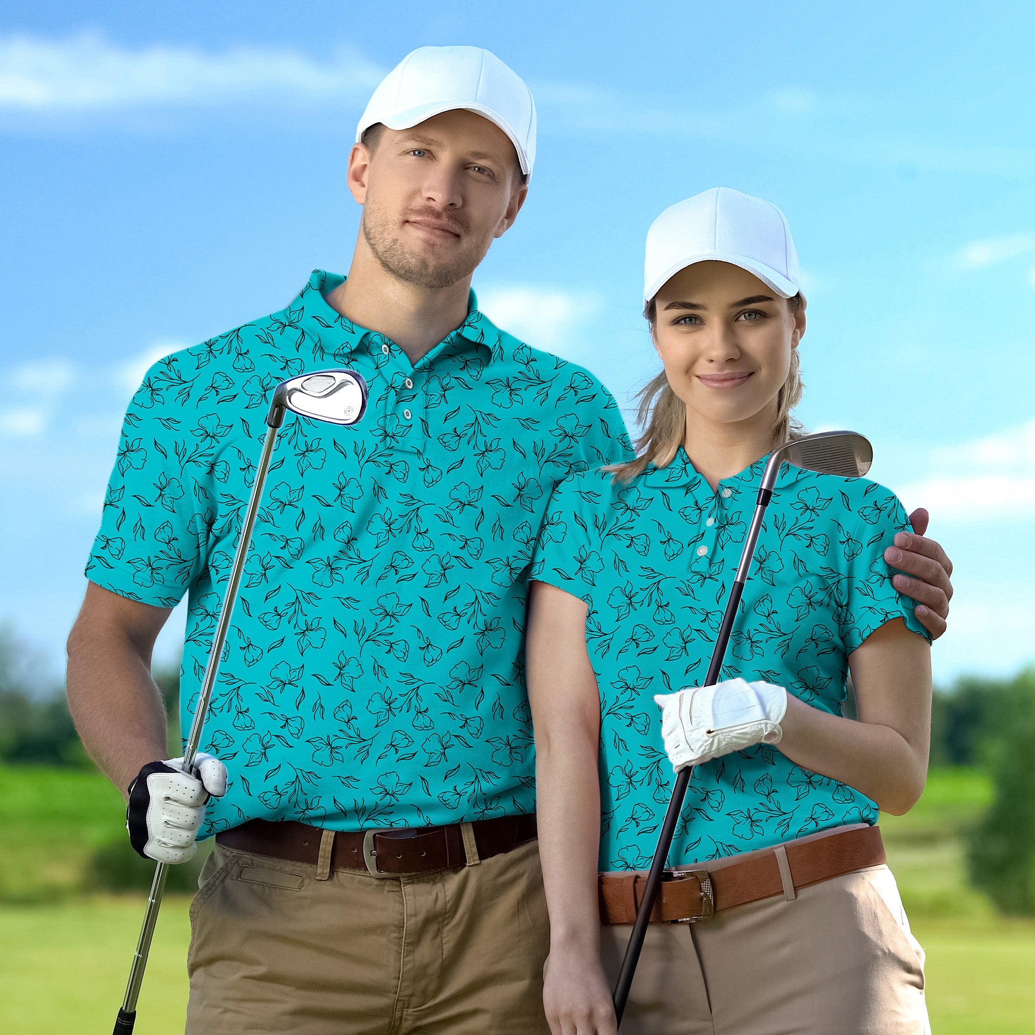 Couple wearing matching teal floral golf polo shirts and white caps holding golf clubs on a sunny golf course