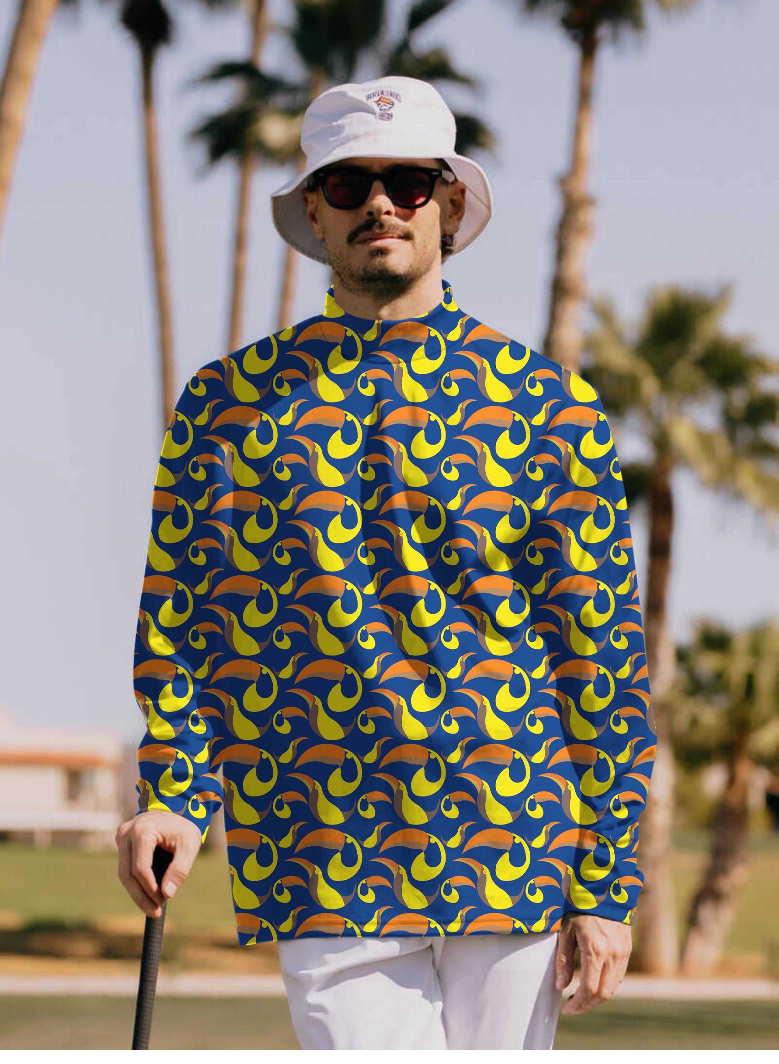 Men's toucan high neck pullover long sleeve t-shirt with vibrant yellow and blue pattern worn outdoors