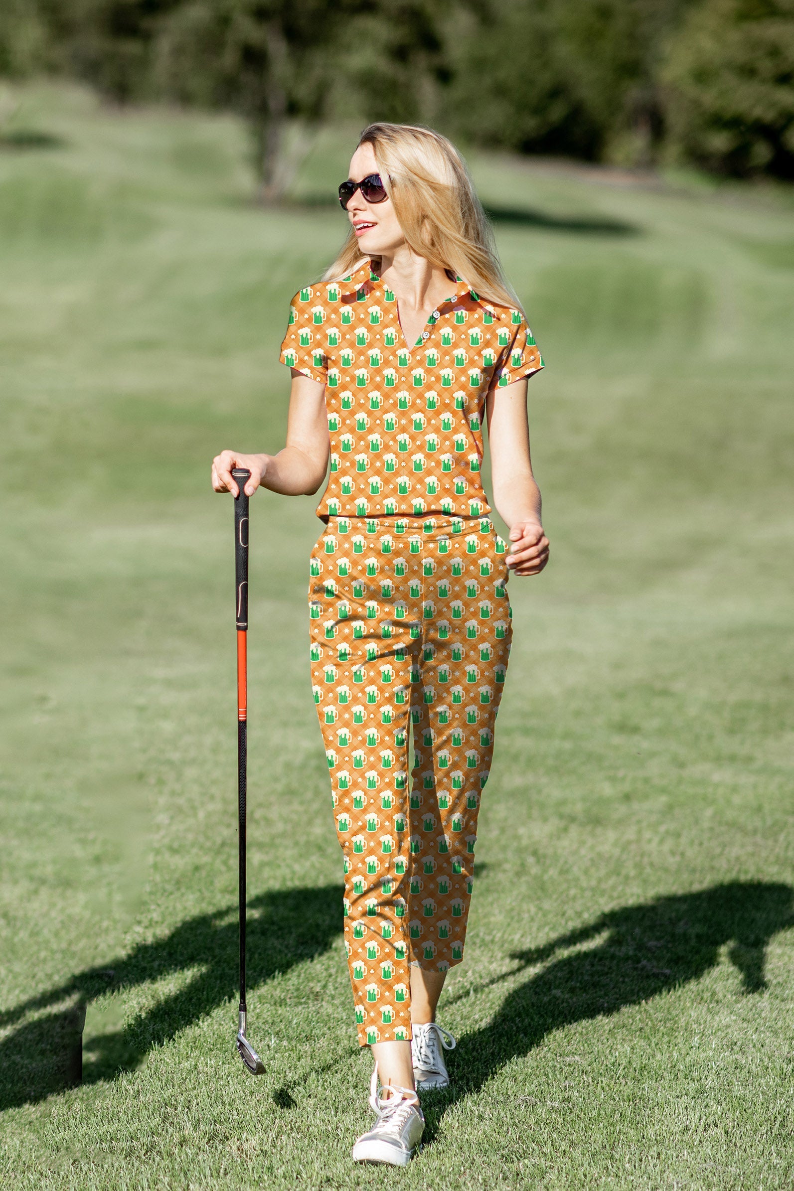 Women's golf polo and pants set with green beer and clover leaf St. Patrick's Day design on the golf course