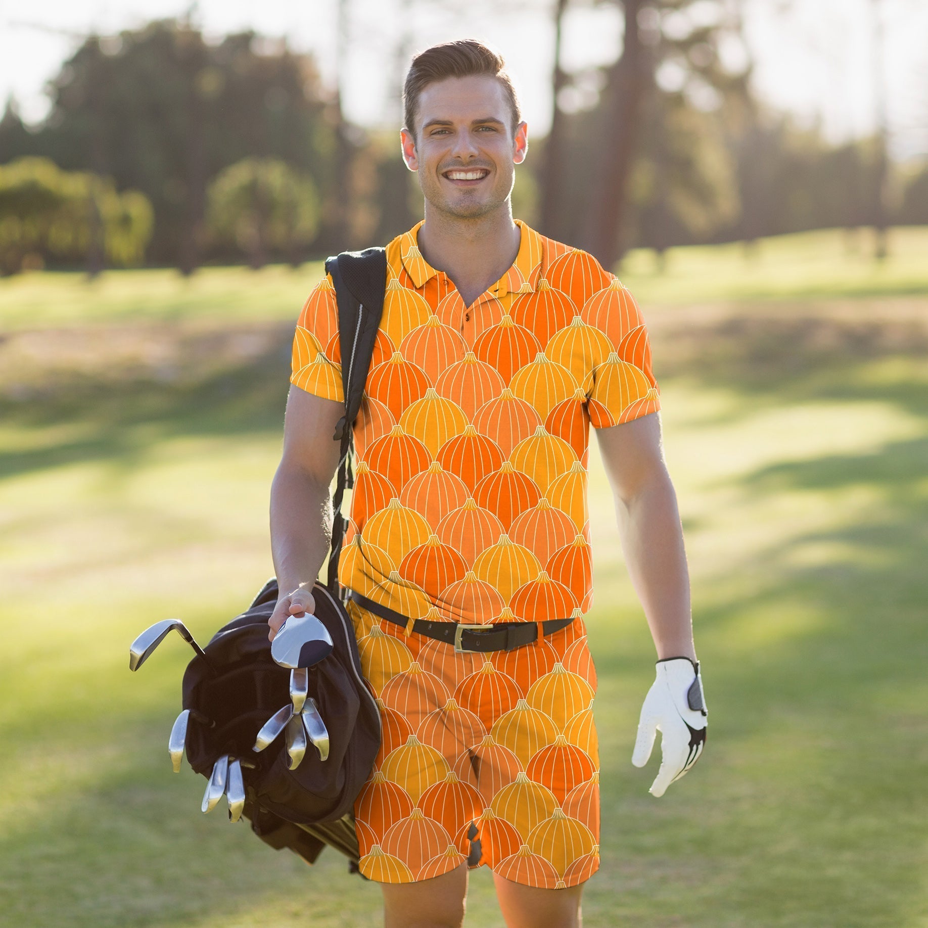 Men's golf set with Halloween-themed orange pumpkin patterned polo shirt and shorts on a golf course