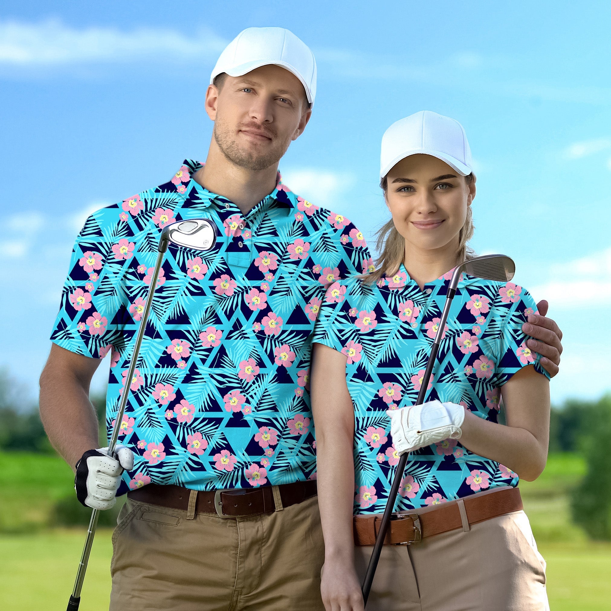 Couple wearing customized Tropical Bloom set golf shirts with white caps holding golf clubs on course