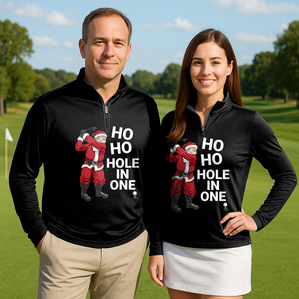 Couple wearing black Santa Claus Play Golf active 3/4 zip tops with "HO HO HOLE IN ONE" text and Santa graphic on golf course