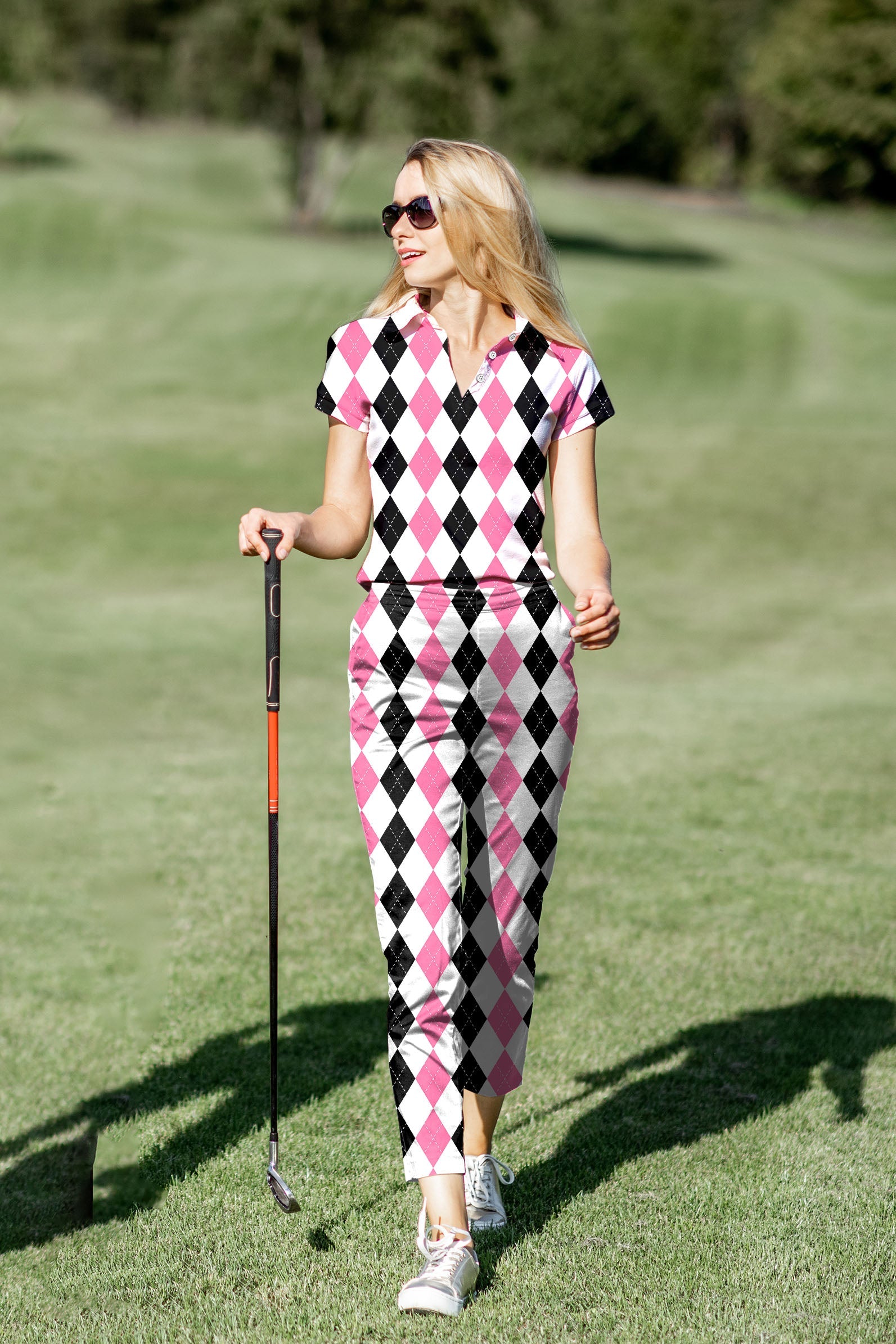 Women's golf polo and pants set in pink and black argyle pattern with four-way stretch and UV protection