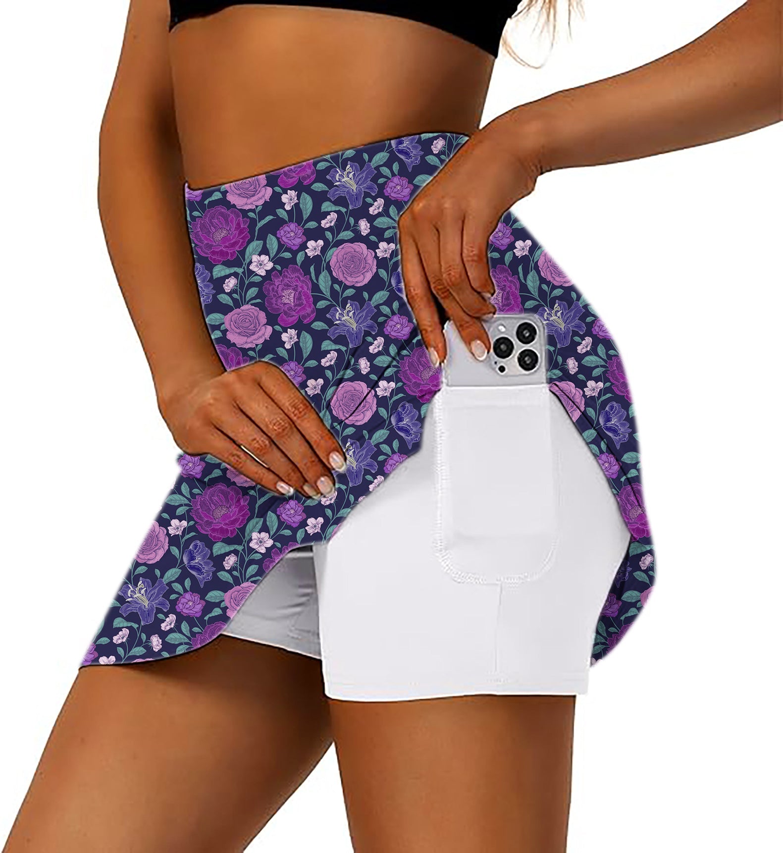Women's purple floral golf skirt with inner shorts and pocket holding a smartphone