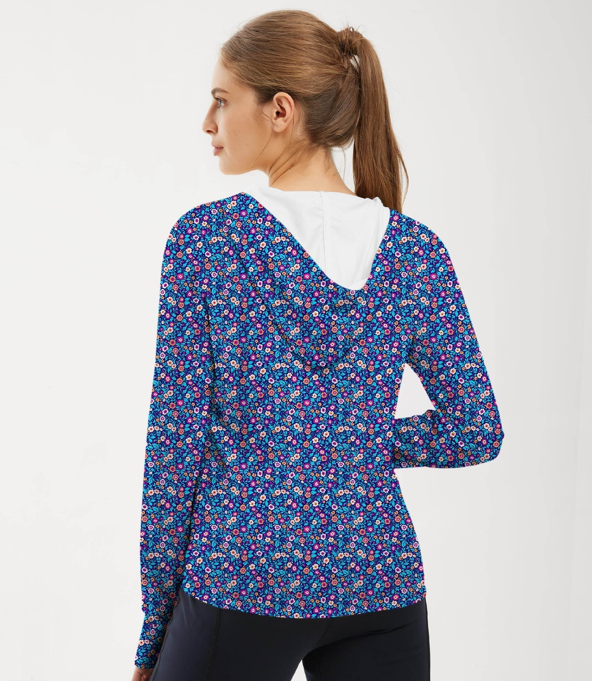 Woman wearing dark floral slim fit zip hoodie for outdoor sports with sun protection and thumb holes