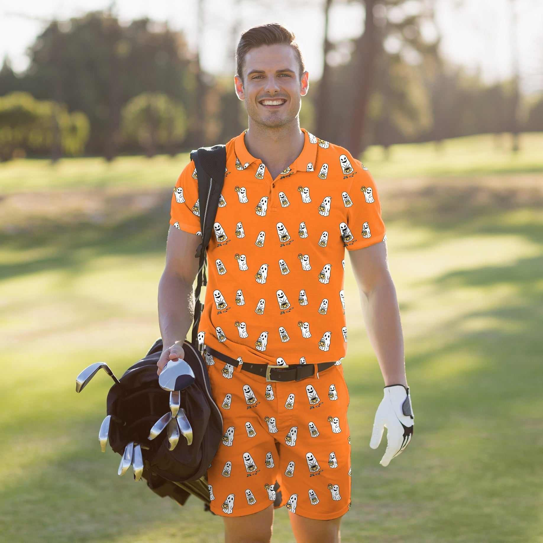 Men's golf set with Halloween ghost and pumpkin design polo and shorts on golfer carrying bag outdoors