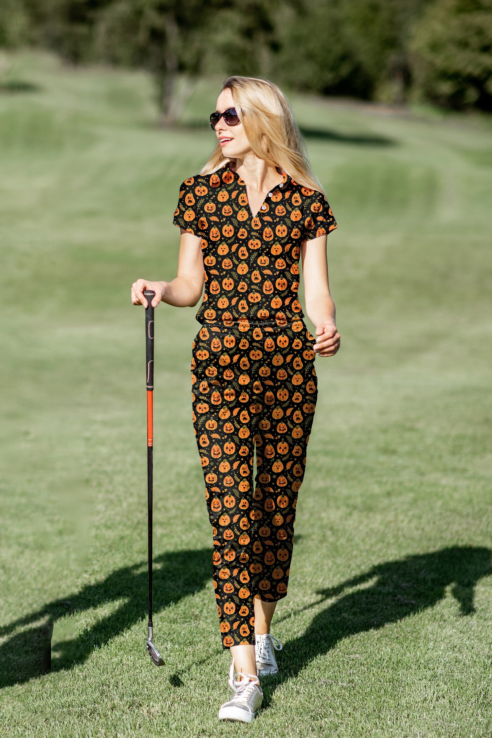 Women's golf polo and pants set with Halloween pumpkin and bones pattern on golf course