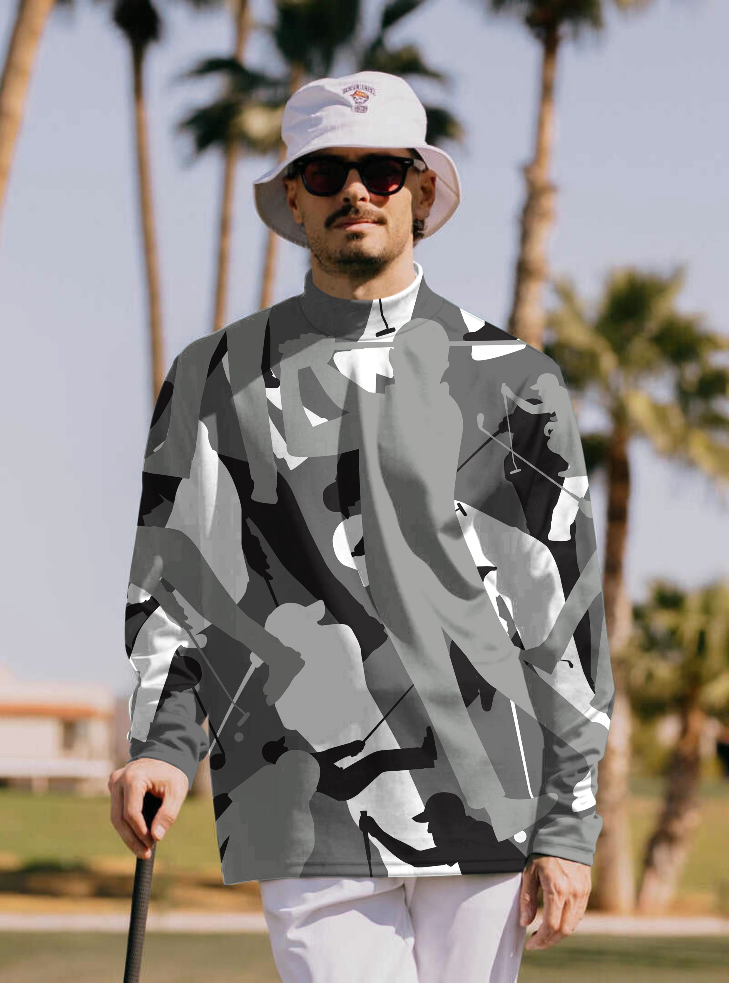 Men's black and white golf pullover with high neck, long sleeves, worn by golfer outdoors