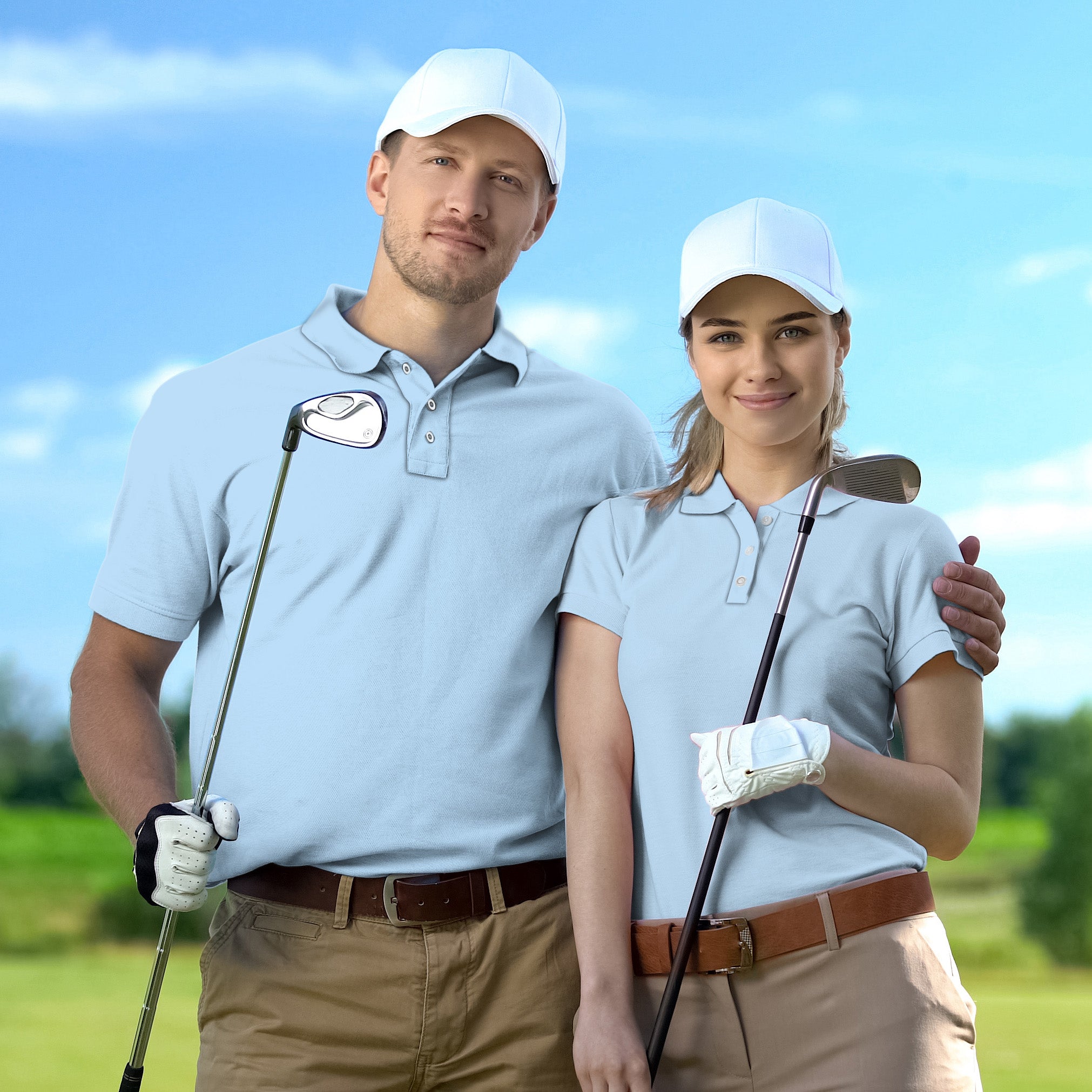 Couple wearing pure sky set golf attire with caps holding golf clubs on course
