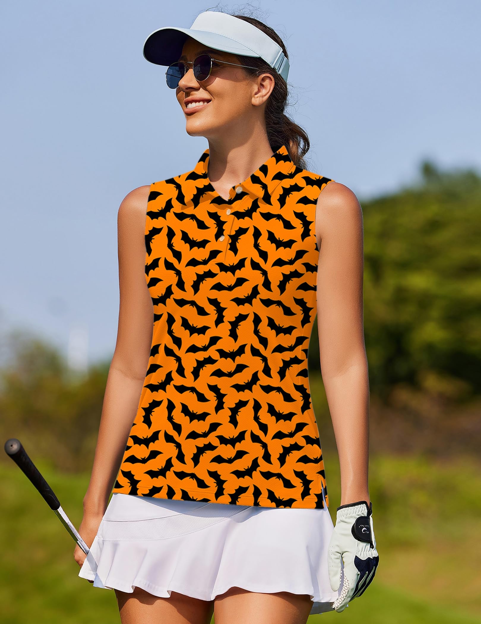 Women's sleeveless golf shirt with custom Halloween bat pattern on orange background