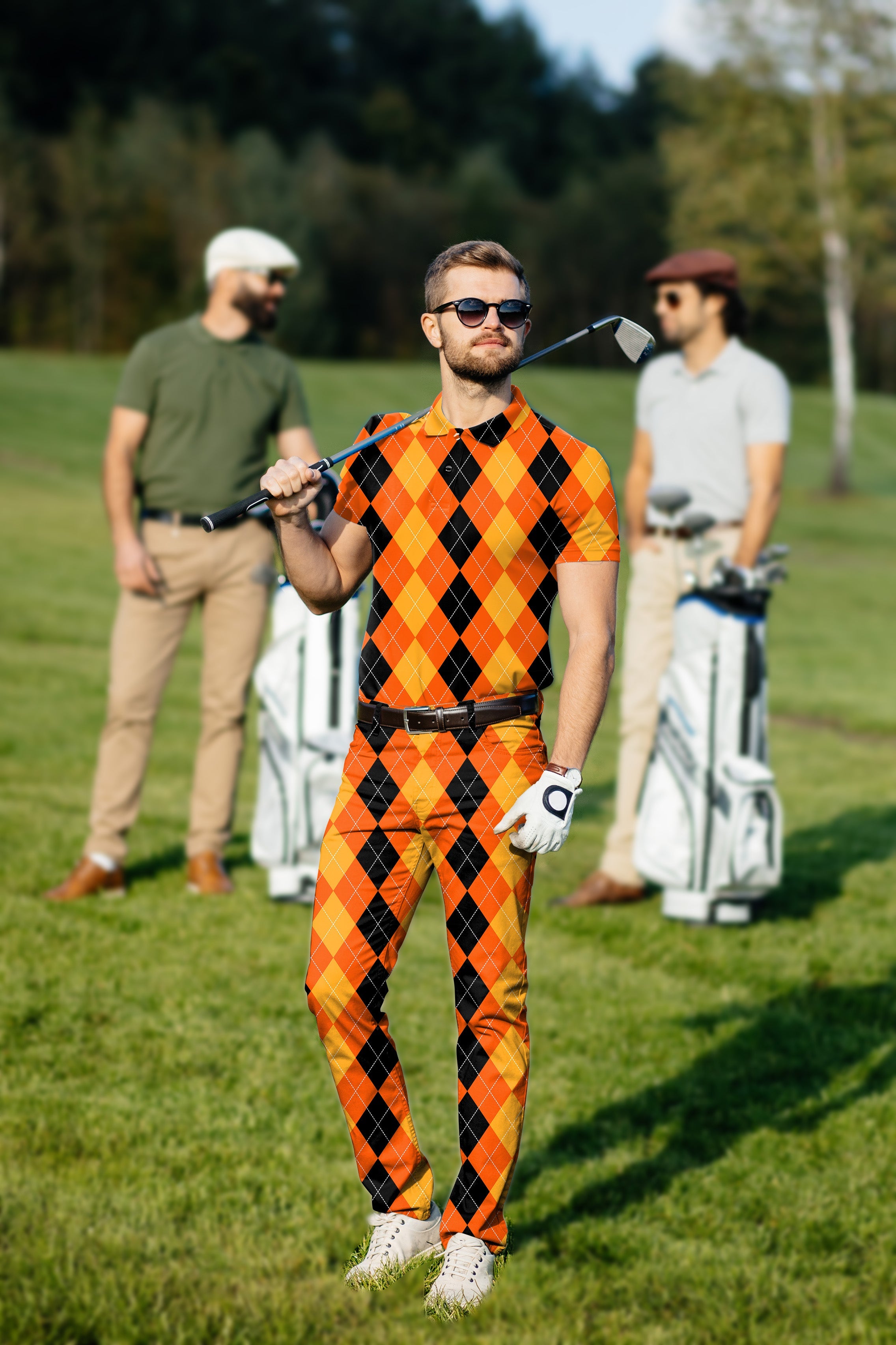 Men's golf set with black, yellow, and orange argyle polo and pants on a golf course