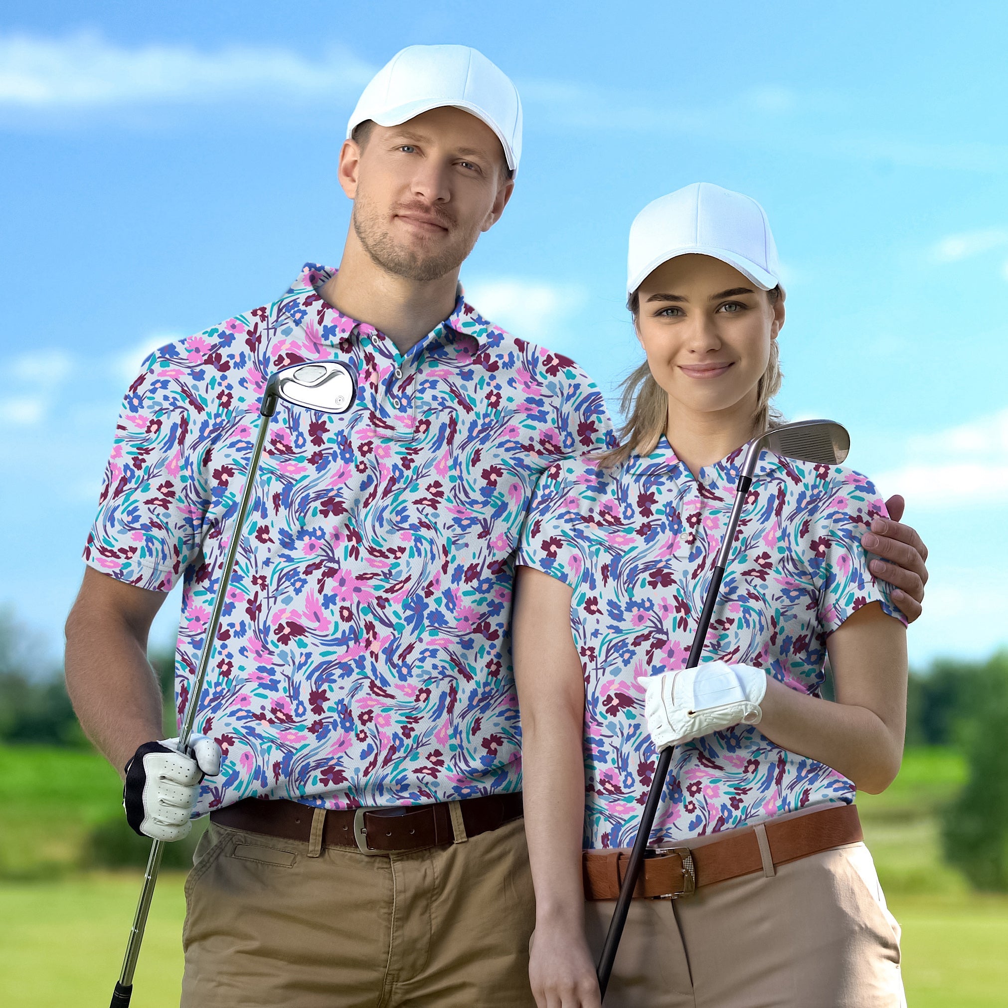 Couple wearing matching floral golf polos with white caps holding golf clubs on a sunny course