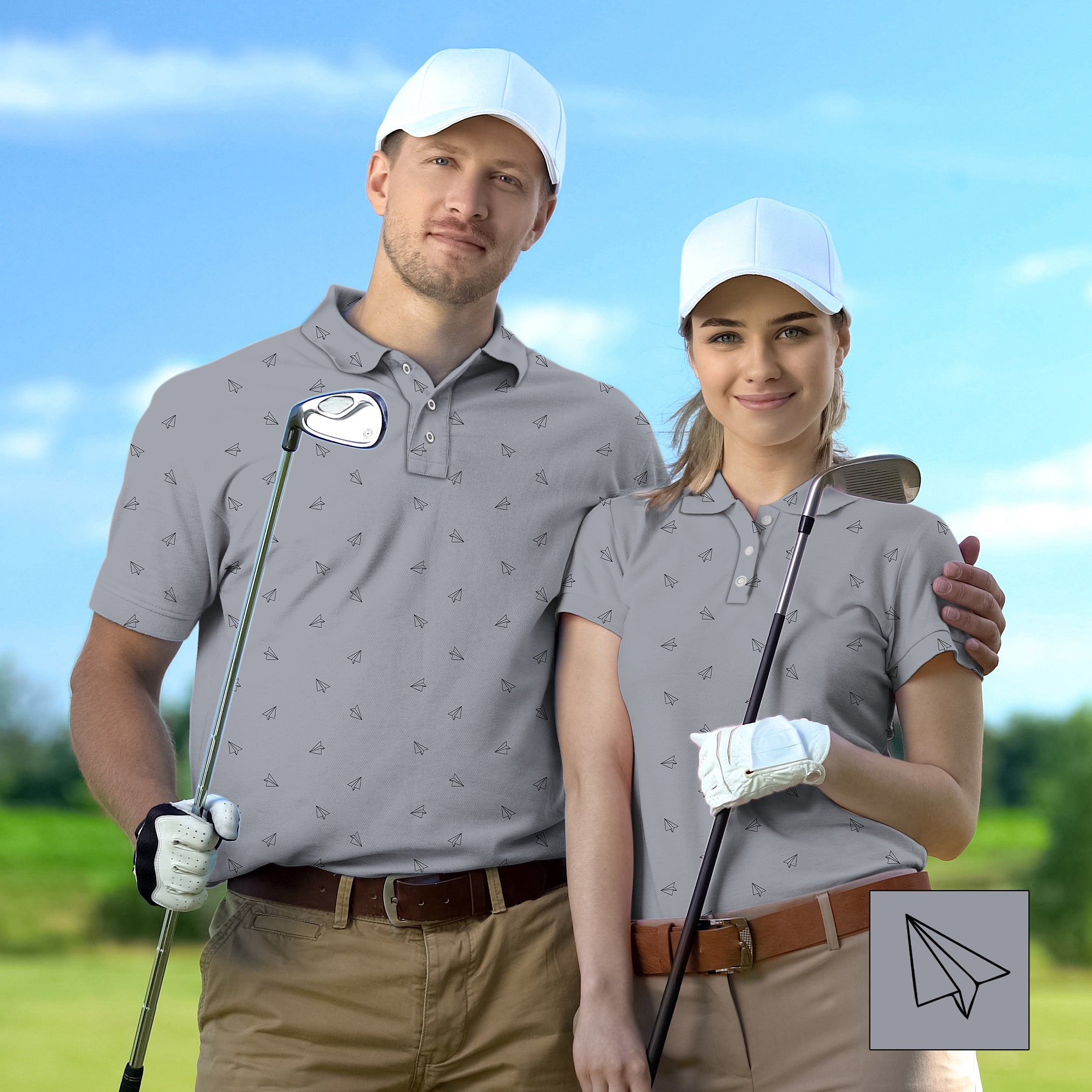 Couple wearing custom gray golf polos with paper airplane pattern holding golf clubs on green course