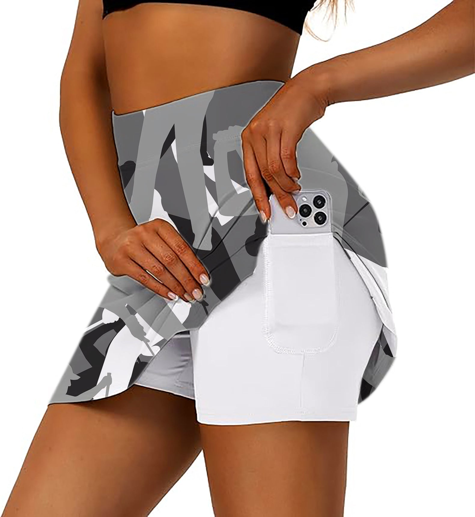 Black and white women's athletic golf skort with side pocket holding smartphone