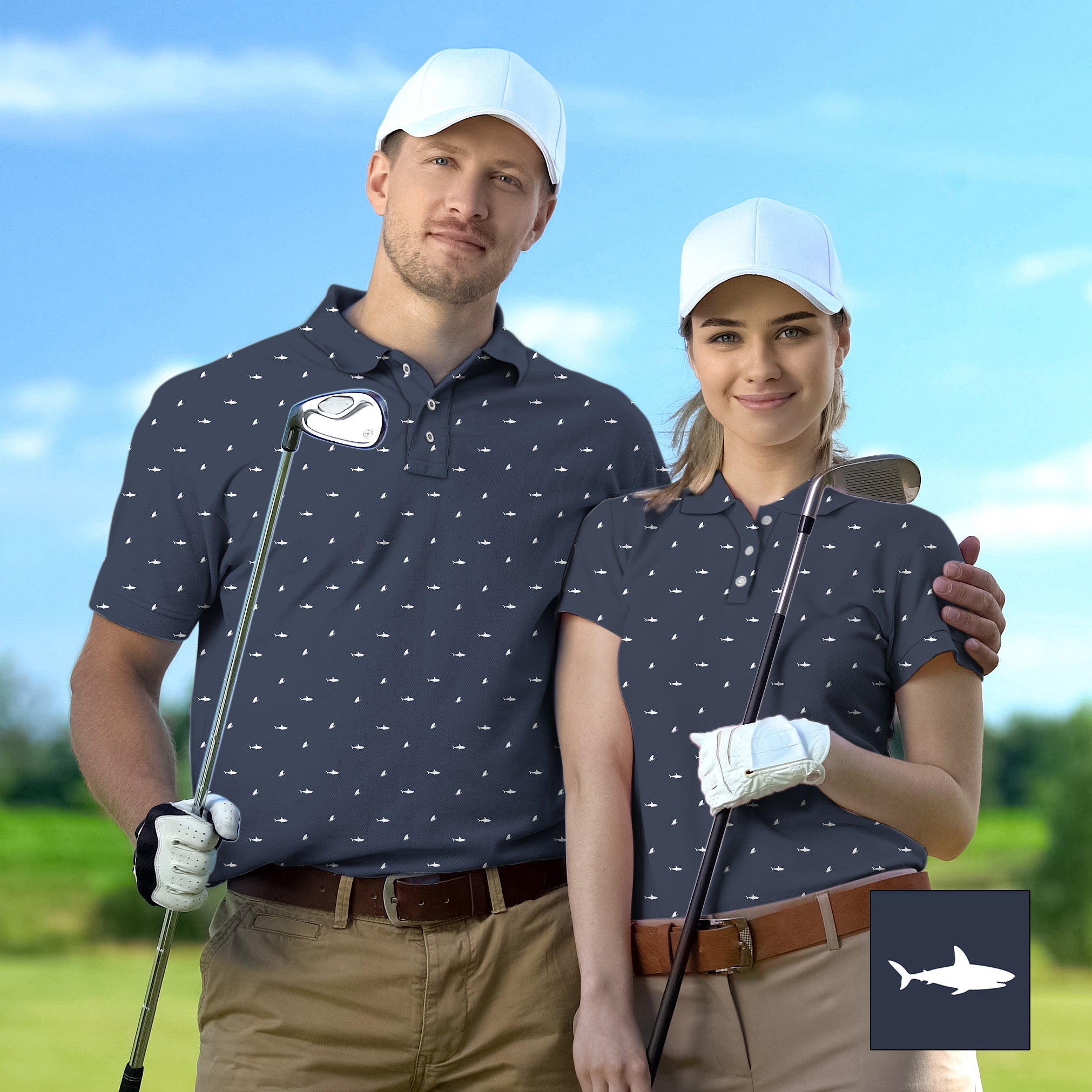 Couple wearing matching navy blue white shark print golf shirts with white caps and beige pants on a golf course