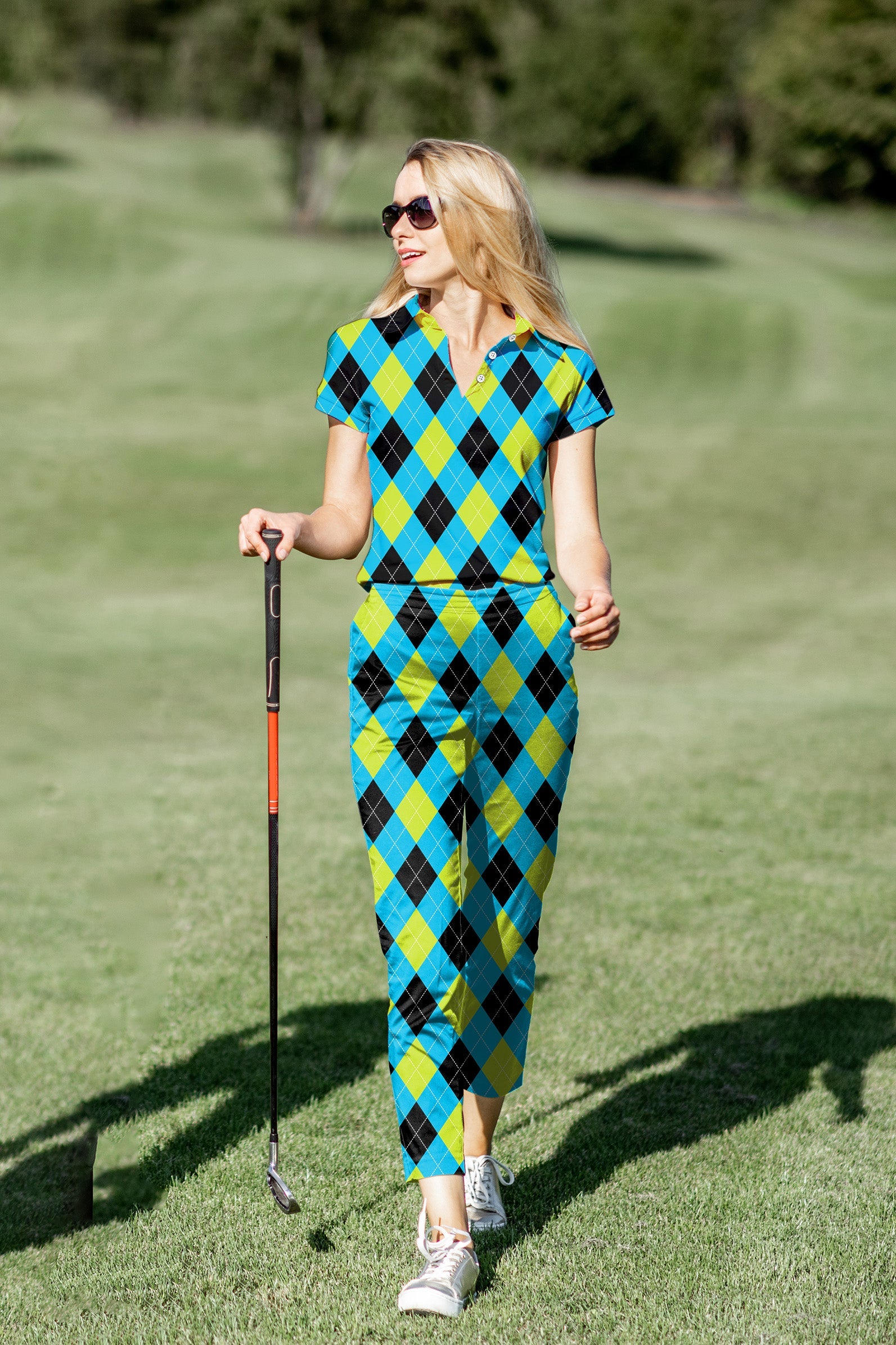 Women's golf polo and pants set in blue and green argyle pattern with breathable, stretchy fabric designed for comfort and style on the course