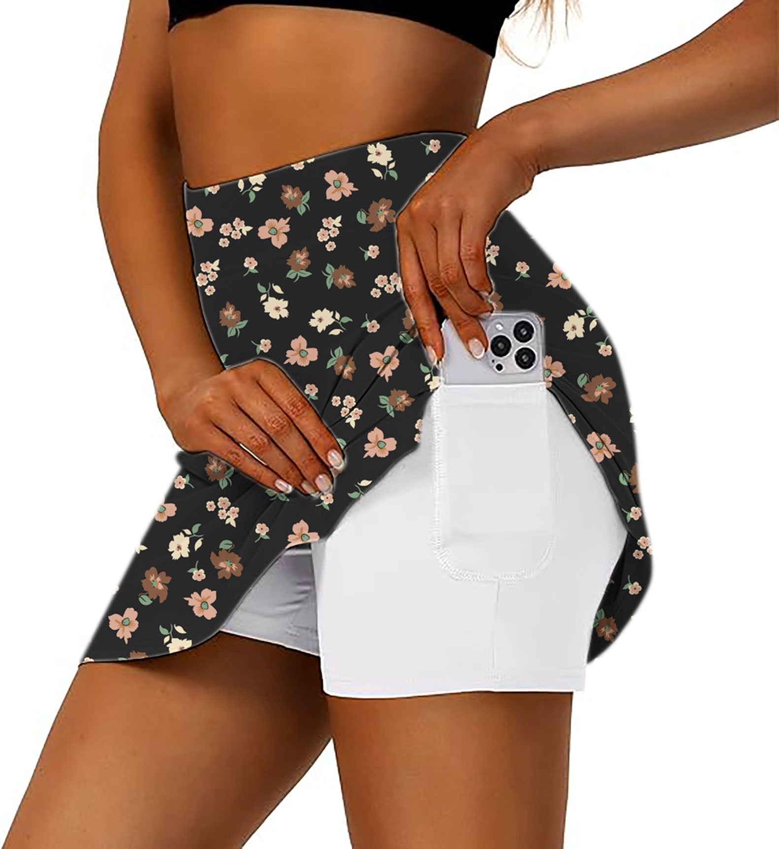 woman wearing black flower athletic golf skorts with flared floral skirt and smartphone pocket