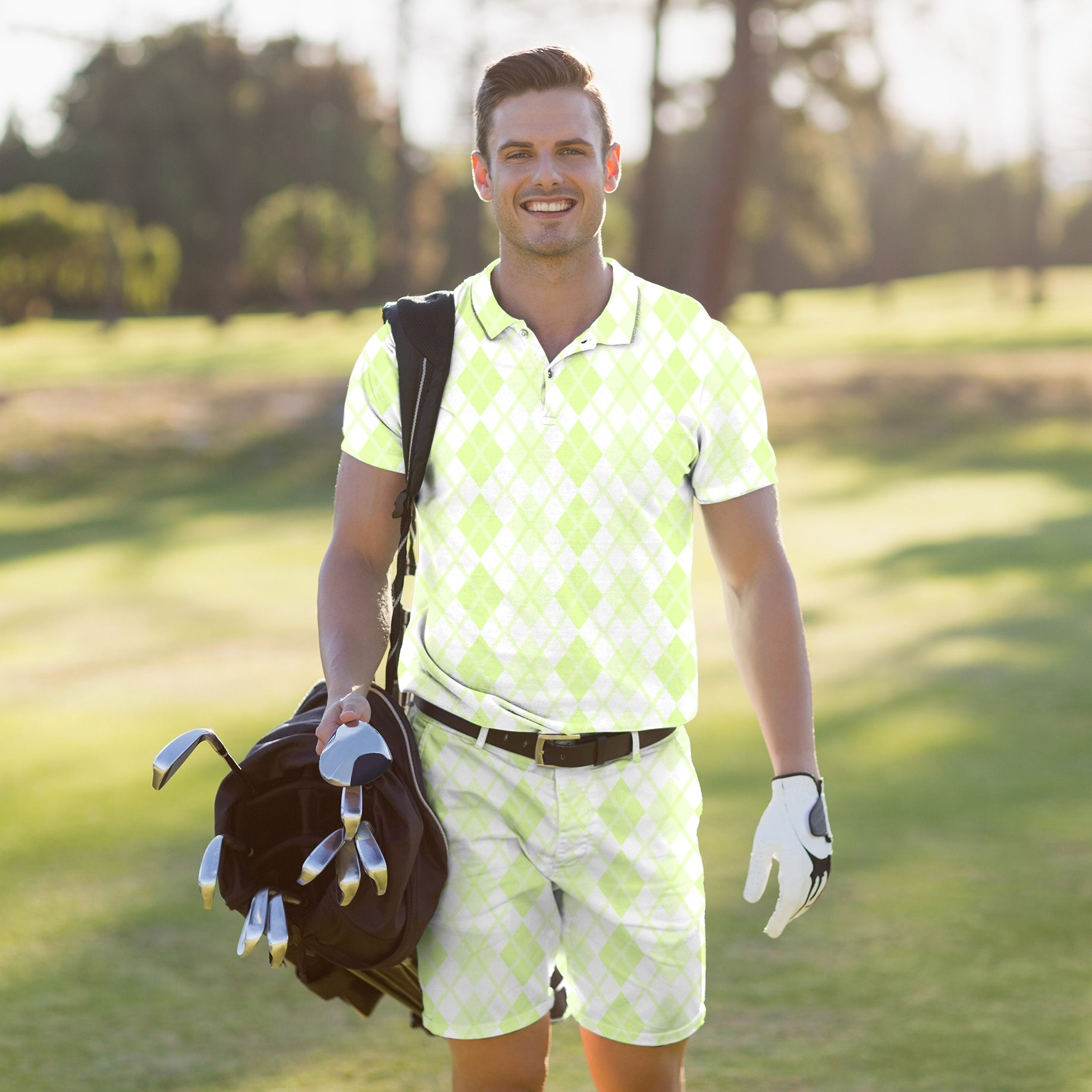 Man wearing green grid men's golf set polo and shorts carrying golf bag on golf course